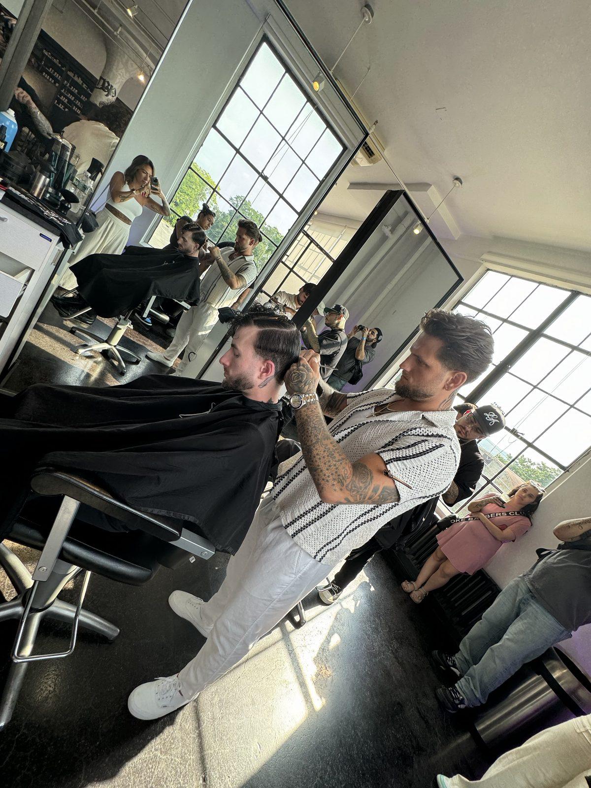 The Ascension floor mid-service — barbers at the chairs, mirrors and studio windows behind.